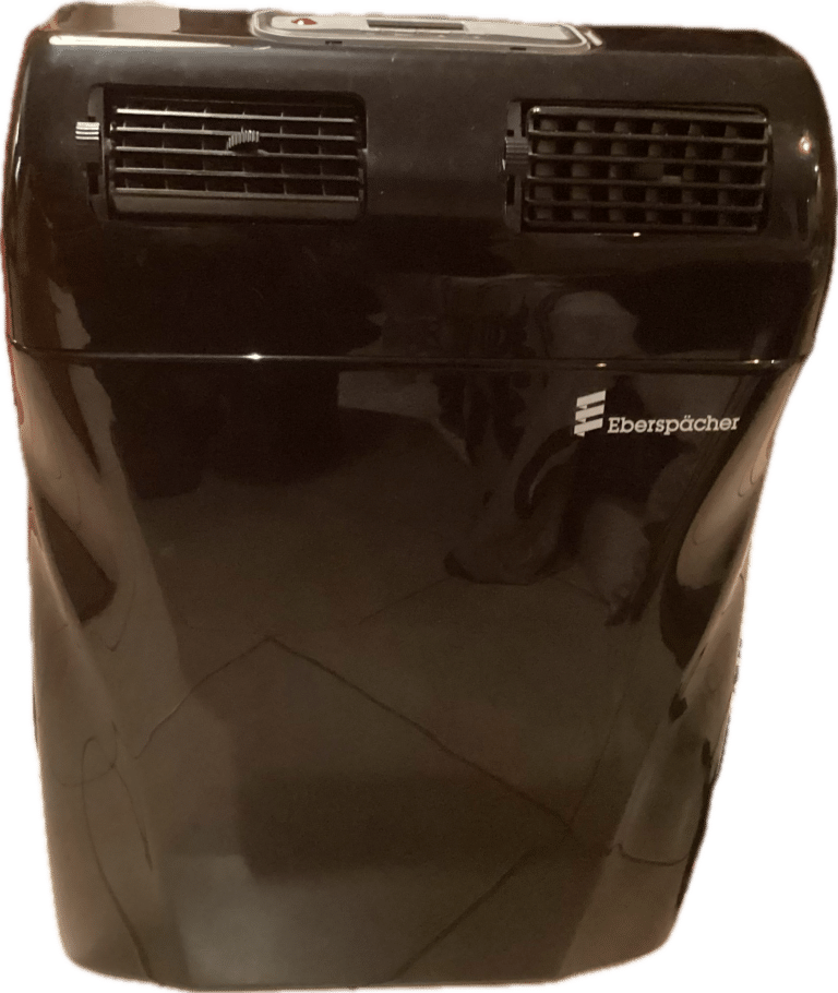 Chauffage portable noir, grille d'aération visible.
