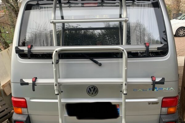 Fourgon Volkswagen California stationné sous un abri.