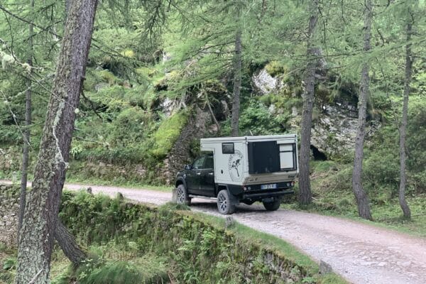 Ausgebauter LKW fährt auf Waldwegen.