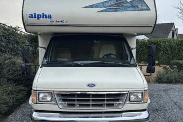 Wohnmobil Ford weiß auf einem gepflasterten Weg.