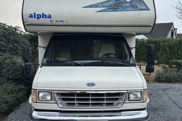 Wohnmobil Ford weiß auf einem gepflasterten Weg.