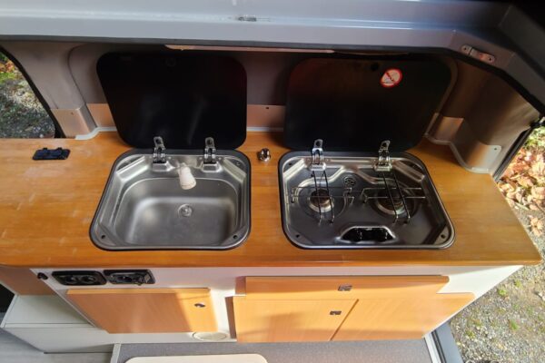 Cuisine camping-car avec évier et plaque cuisson.