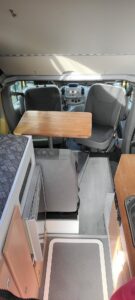 Intérieur d'un camping-car avec table et sièges.