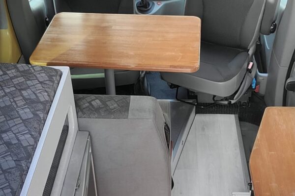 Intérieur d'un camping-car avec table et sièges.