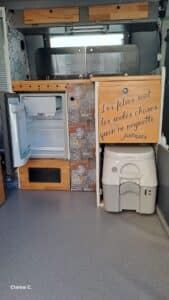 Intérieur de van aménagé avec frigo et toilettes