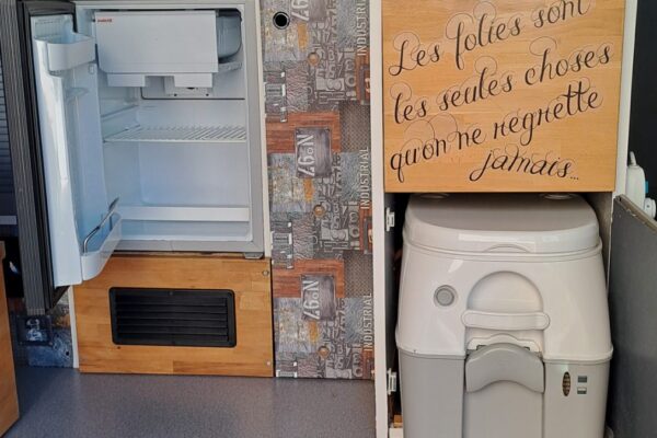 Intérieur de van aménagé avec frigo et toilettes
