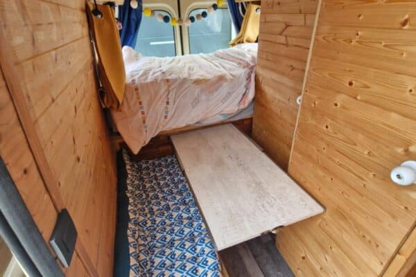 Intérieur de van aménagé en bois avec lit