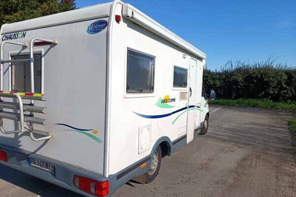 Camping-car blanc stationné au bord d’une route