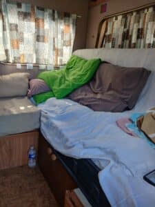 Lit aménagé dans un van avec coussins colorés
