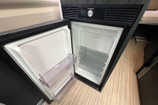 Petit réfrigérateur encastré ouvert et vide