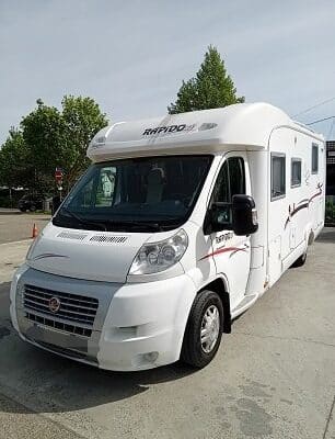 Camping-car blanc stationné sur un parking