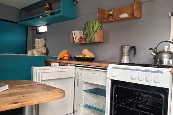 Petite cuisine aménagée avec four et réfrigérateur ouverts