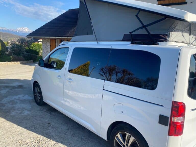Van aménagé blanc avec toit relevable ouvert