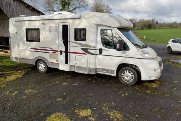 Camping-car blanc garé à la campagne