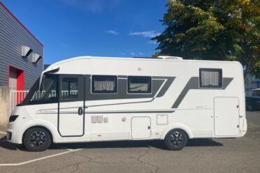 Camper bianco parcheggiato sotto il cielo blu