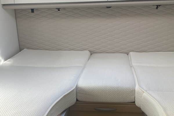 Espace couchage de camping-car avec matelas blancs
