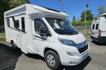 Camping-car blanc stationné sous ciel bleu
