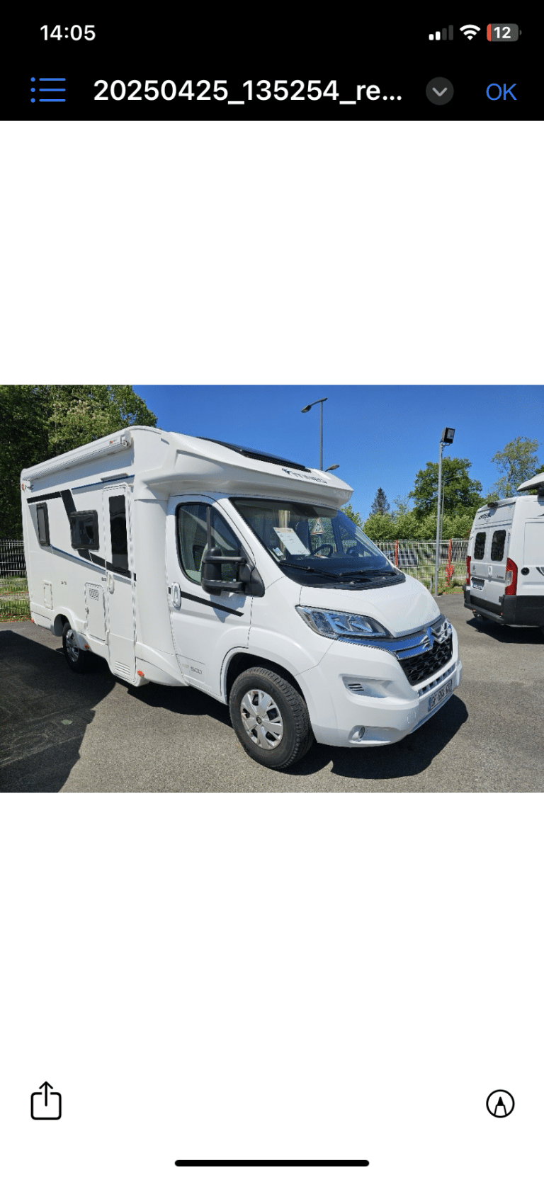 Camping-car blanc stationné sous ciel bleu