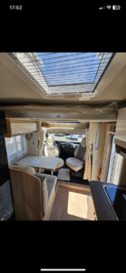 Intérieur lumineux d’un camping-car avec table et lanterneau