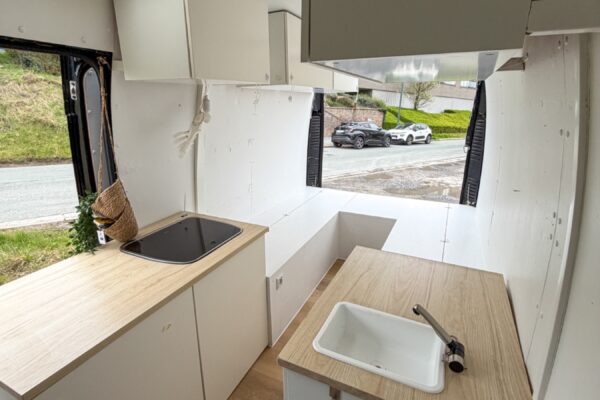 Aménagement cuisine minimaliste dans van avec rangements blancs