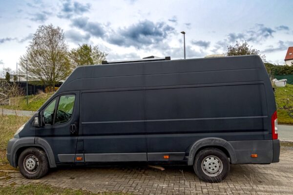 Grand fourgon utilitaire noir stationné en extérieur