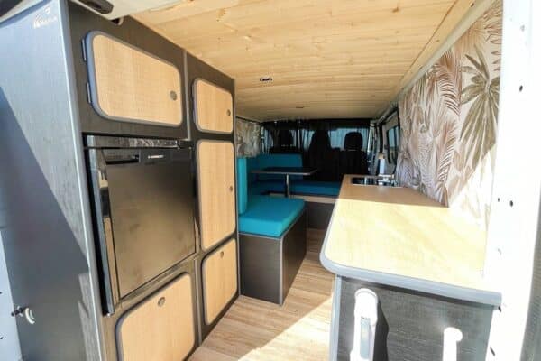 Intérieur aménagé de van avec kitchenette et banquettes