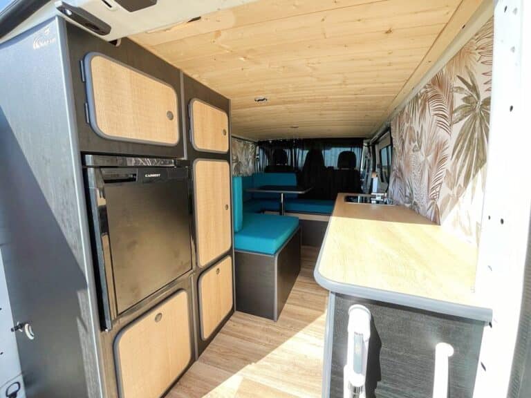 Intérieur aménagé de van avec kitchenette et banquettes