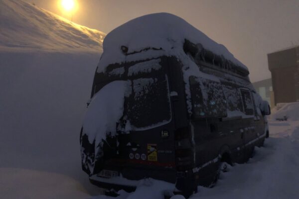 Camping-car enseveli sous la neige au coucher du soleil