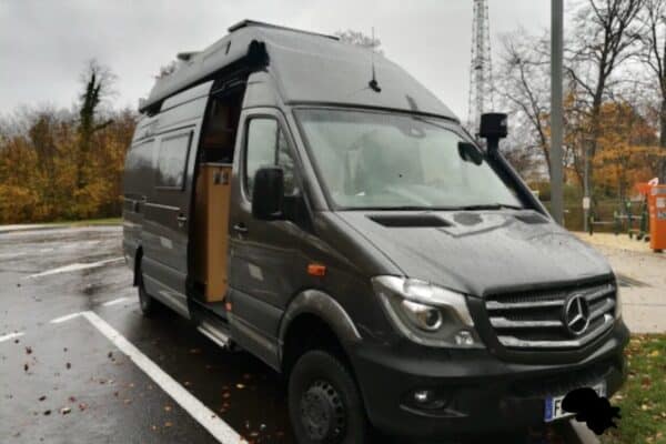 Fourgon aménagé Mercedes garé sous la pluie