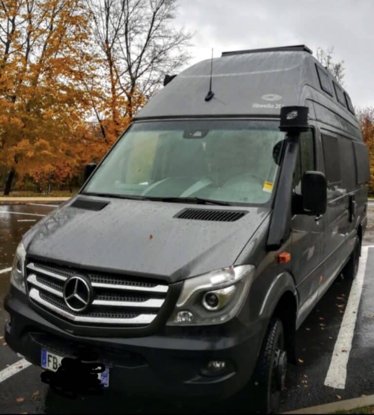 Camping-car Mercedes gris sous pluie d’automne