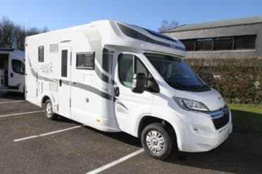 Camping-car blanc stationné sur un parking