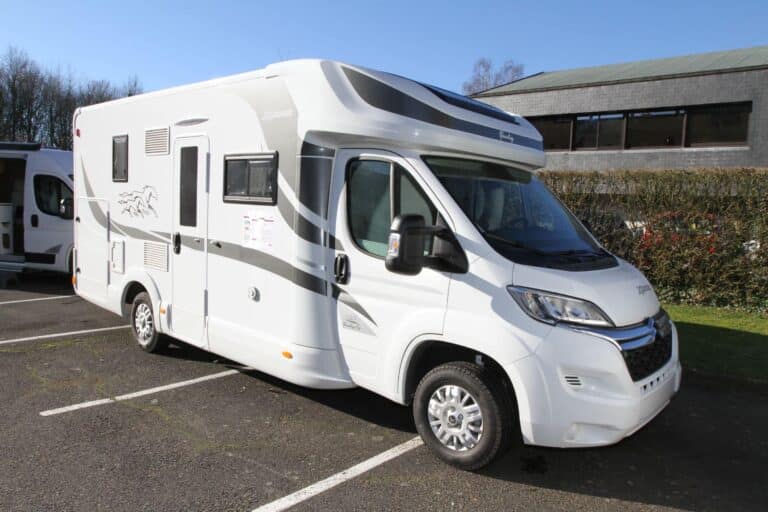 Camping-car blanc stationné sur un parking