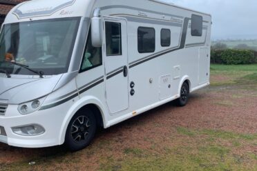 Camping-car blanc stationné en pleine campagne