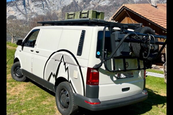 Van aménagé avec galerie, garé en montagne