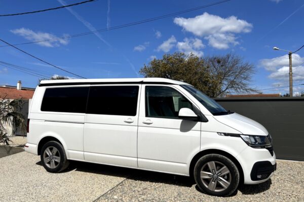 Van blanc stationné dans une cour ensoleillée