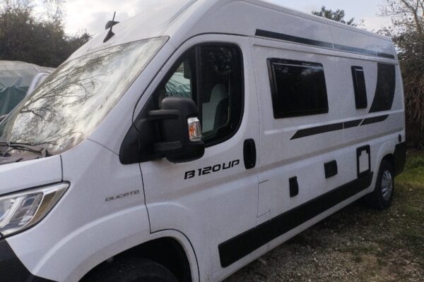 Fourgon aménagé blanc stationné en extérieur