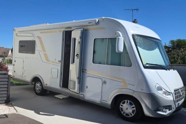 Camping-car blanc stationné dans une allée résidentielle