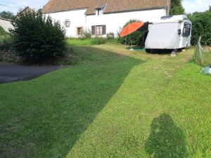 Camping-car stationné dans jardin près maison rurale
