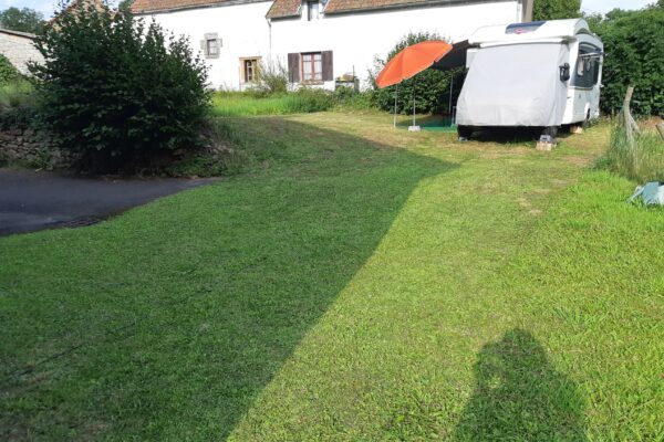 Camping-car stationné dans jardin près maison rurale