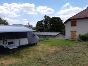 Caravane stationnée dans un jardin près d’une maison
