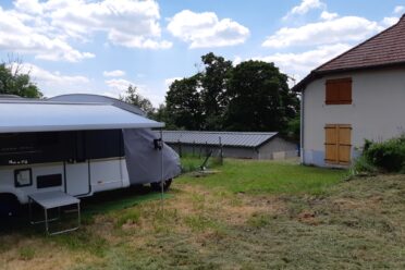 Caravane stationnée dans un jardin près d’une maison