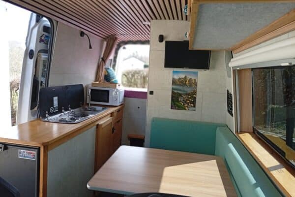 Intérieur aménagé de van avec kitchenette et banquette