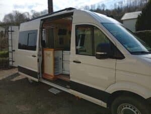 Fourgon aménagé blanc avec kitchenette et réfrigérateur ouverts