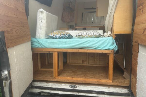 Intérieur de van aménagé avec lit en bois
