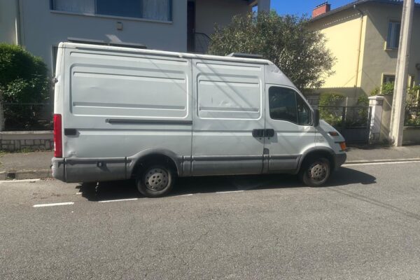 Fourgon blanc stationné dans rue résidentielle ensoleillée