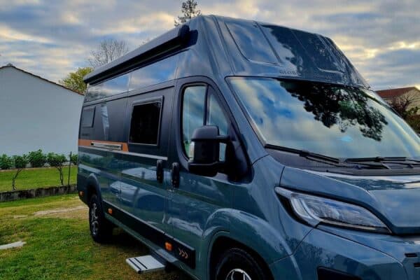 Fourgon aménagé moderne garé sur pelouse résidentielle