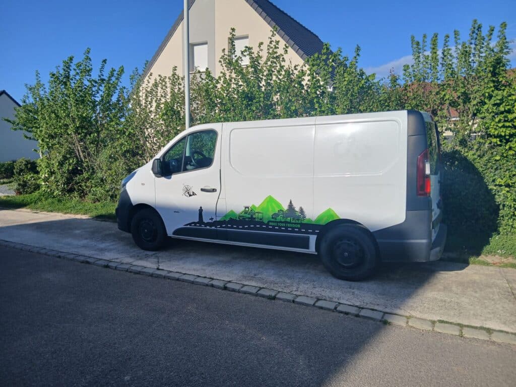 Fourgon blanc décoré montagnes stationné quartier résidentiel