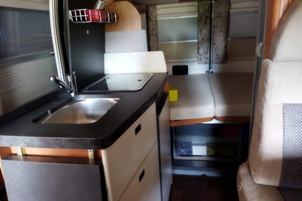 Interno camper con cucina compatta e letto