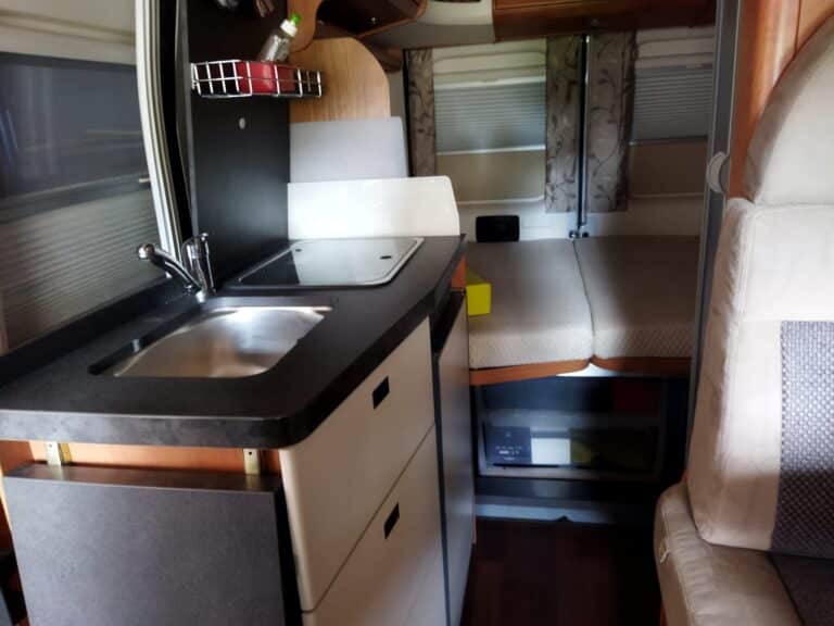 Interno camper con cucina compatta e letto