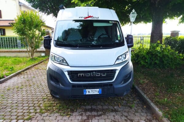 Camper bianco Malibu parcheggiato su vialetto alberato